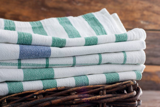 Clean kitchen towels stacked in a basket on the basket, selective focus