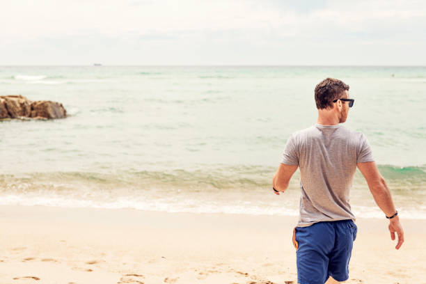 istock Man enjoying Pedn Vounder Beach, Cornwall on a Summers day. 1057938616