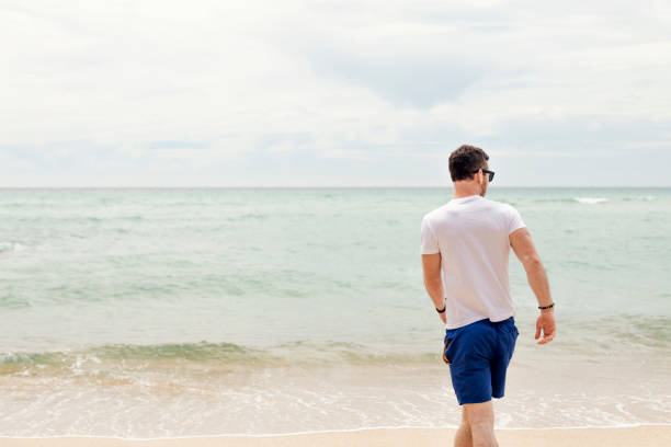 istock Man enjoying Pedn Vounder Beach, Cornwall on a Summers day. 1057938654