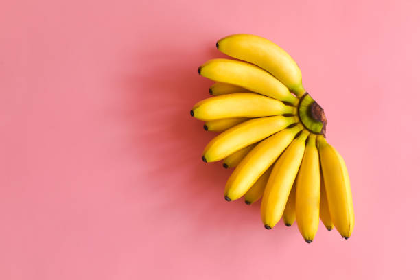 top view of ripe bananas on a bright pink background. - top sirloin imagens e fotografias de stock