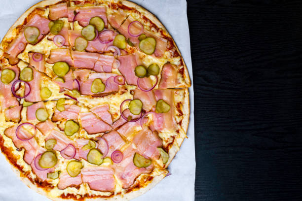 istock pizza with bacon ham on wooden table, Top view 1057938856