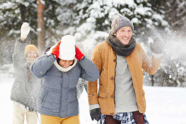 istock Jolly young friends playing in snow 1057945466