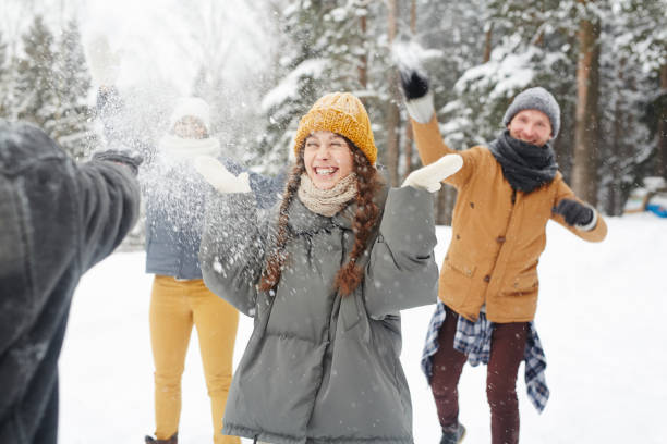 istock Happy friends having snowball fight 1057945486