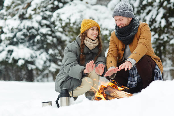 istock Beautiful couple sitting by fire in winter 1057945534