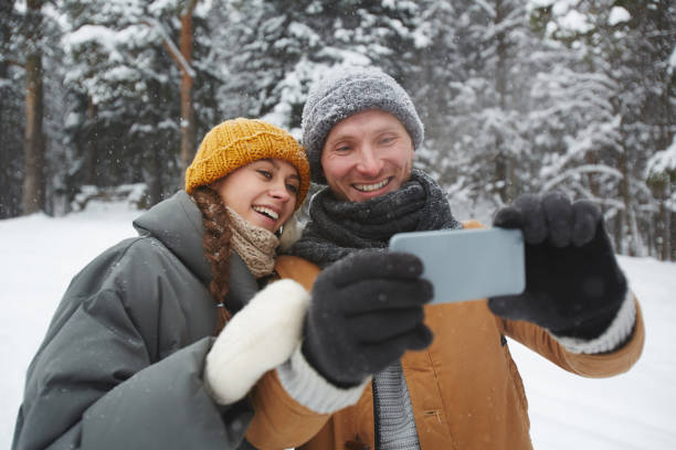 istock Jolly couple smiling while taking selfie in forest 1057945624