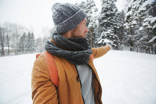istock Young man showing direction in winter forest 1057945668
