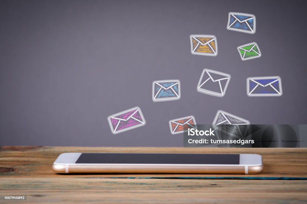 e mail marketing concept e mail marketing concept. Media Technology concept. Mobile phone on a wooden table and a gray background E-Mail Stock Photo