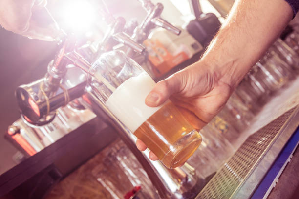 istock Bartender pouring fresh beer from beer tap. 1057952696