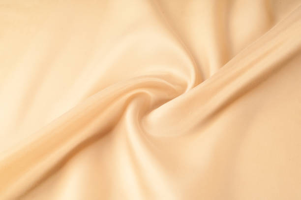 istock Texture background of fabric. Beige fabric. Silk fabric wallpaper texture background pattern in sepia pastel yellow cream beige tint: Lovely natural silk textured textile 1057958456