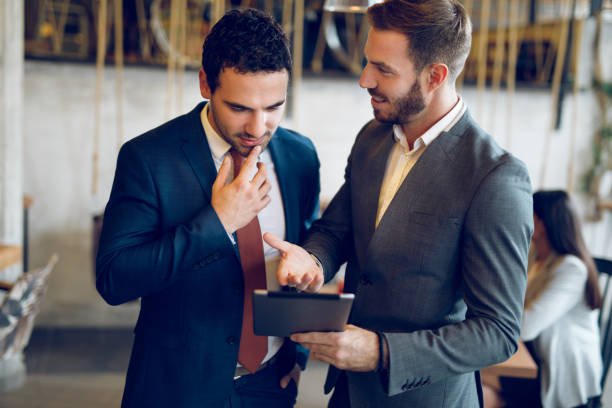 istock Two young businessmen discussing business strategy using digital tablet 1057962962