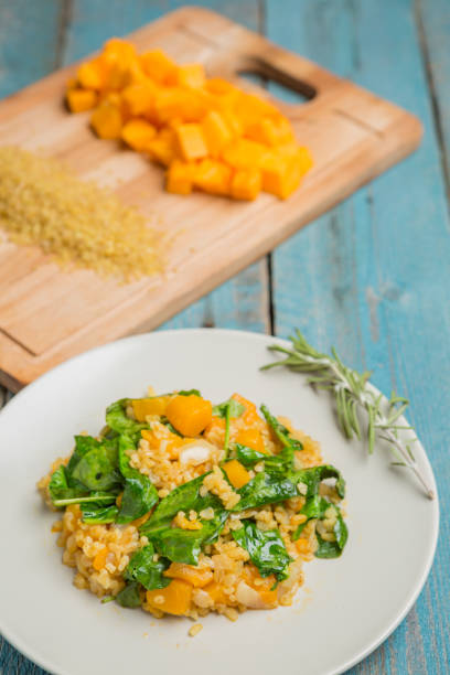 istock Bulgur with pumpkin and cutting board with ingredients 1057963178