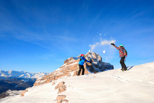 Snow fight. Amateur Winter Sports alpine skiing. Couple best friends men and women, snow skiers enjoying on sunny ski resorts. High mountain snowy landscape. Italian Alps mountain of the Dolomites Italy, Europe. Madonna di Campiglio. nieve la lucha amateur deportes de invierno esquí alpino. dos mejores amigos hombres y mujeres, esquiadores de nieve, disfrutar de estaciones de esquí soleada. paisaje nevado de alta montaña. montaña de los dolomitas de italia, europa en alpes italia