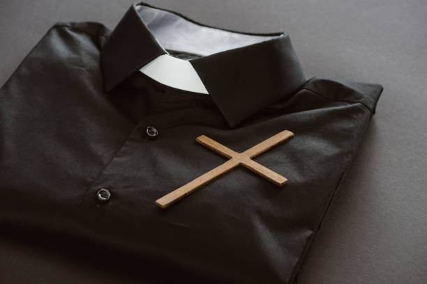 nahaufnahme der klerikalen shirt mit kreuz auf graue oberfläche - priester stock-fotos und bilder