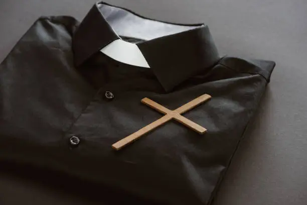 close-up shot of clerical shirt with cross on grey surface
