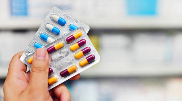 confezione capsula medicinale con tenuta a mano - antibiotico foto e immagini stock