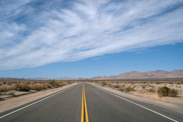 desert highway in california - arid climate asphalt barren blue foto e immagini stock