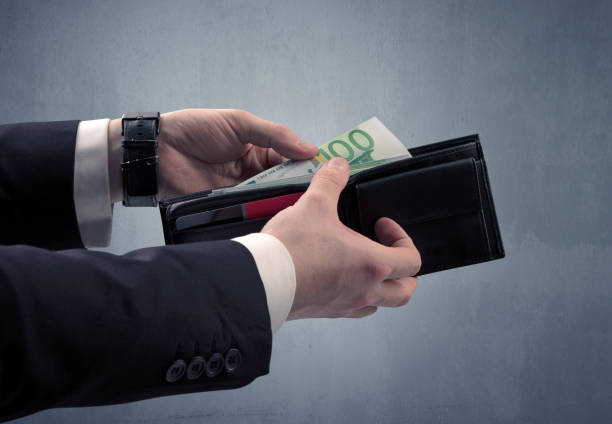 istock Hand in suit takes out euro from wallet 1057978434