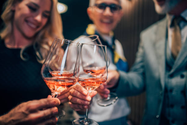 istock Happy people drinking rose wine together 1057978952