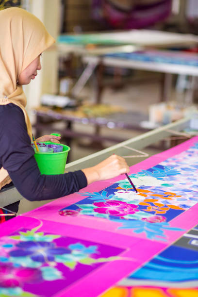 istock Woman painting in a batik workshop 1057982440