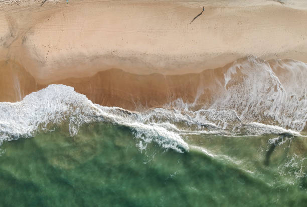 istock Top view of a tropical beach, waves over sand 1057990076