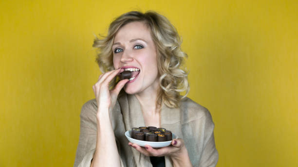 istock A woman with a beautiful smile is eating candy. 1057990252