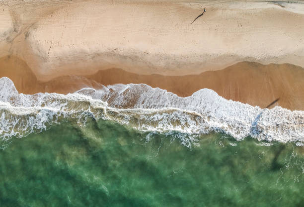istock Top view of a tropical beach, waves over sand 1057992858