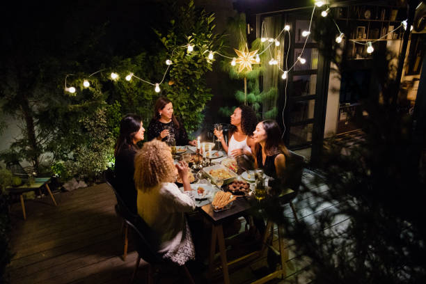 Dinner party Latino women have dinner party at house yard garden lights candle stock pictures, royalty-free photos & images