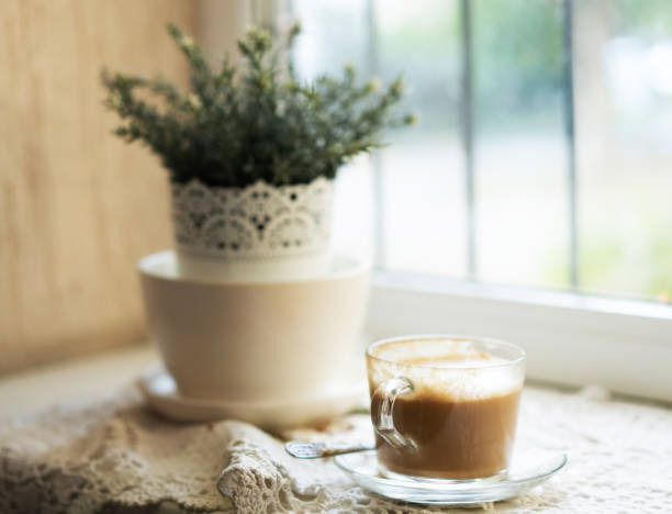 cup of coffee on the windowsill mug of coffee is on the windowsill next to the flower pot кружка stock pictures, royalty-free photos & images