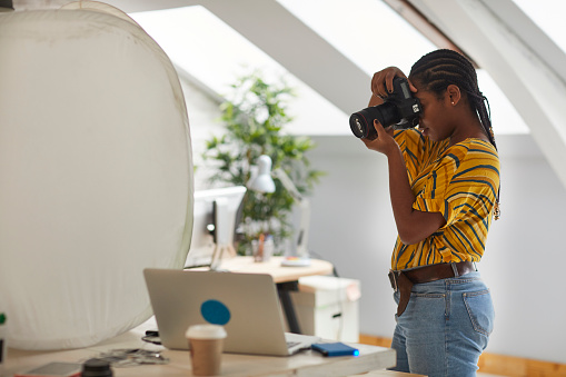 Young African woman, graphic designers working in her studio.
