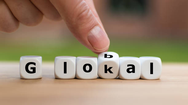 istock Hand is turning a dice and changes the word lokal to global 1057994226