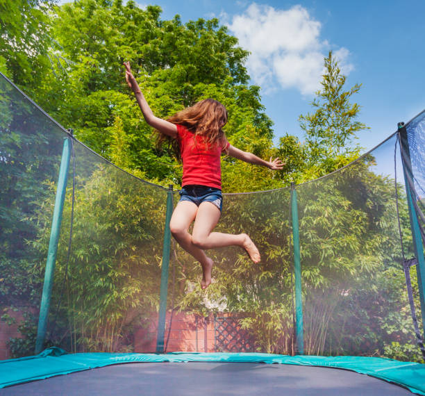 istock Active girl jumping on trampoline outdoors 1057996094