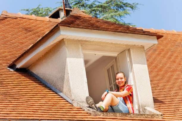 istock Girl looking down to street from open attic window 1057996164