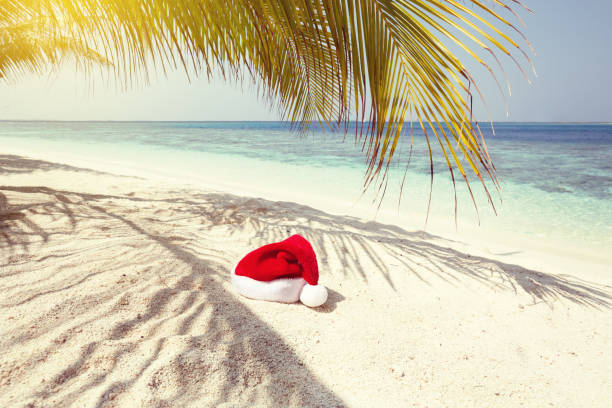 istock Santa Claus hat on perfect tropical beach 1058002360