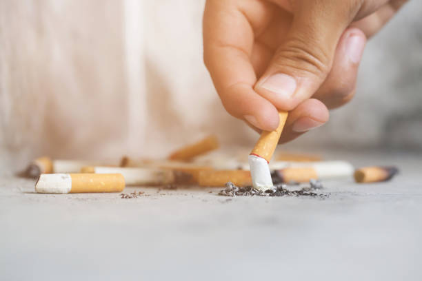istock Hand putting out a cigarette,cigarette butt on Concrete floor, bare cement.	smoking a cigarette. pulverize the floor. 1058003740