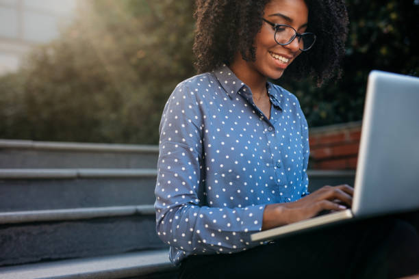 istock Businesswoman sitting on steps outdoors working on laptop 1058004120