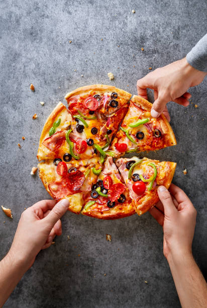 Hands taking fresh pizza slices. Pizza party. Top view. Copy space.