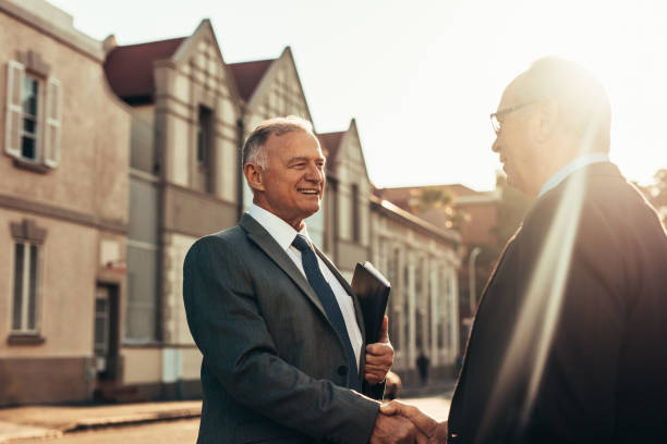 istock Two business partners handshake outdoors 1058006912