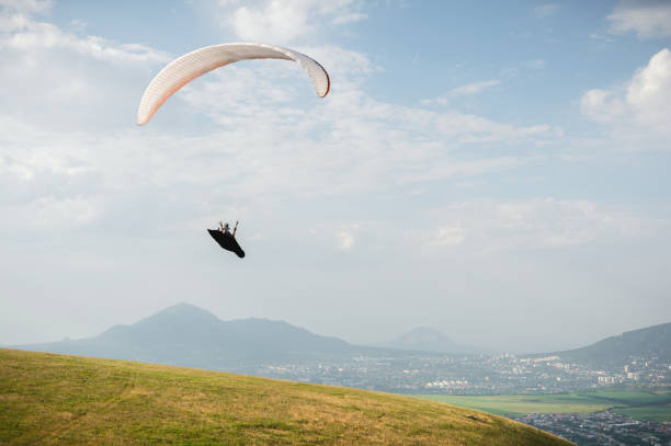 istock A white-orange paraglider flies over the mountainous terrain 1058007326