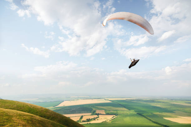 istock A white-orange paraglider flies over the mountainous terrain 1058007440