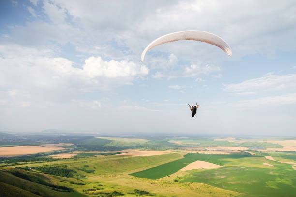 istock A white-orange paraglider flies over the mountainous terrain 1058007442