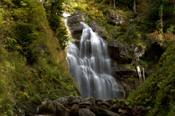 istock Waterfall in the autumn forest. Autumn landscape 1058016680
