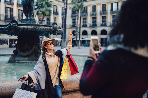 Woman after shopping posing with credit card and shopping bags for a photo