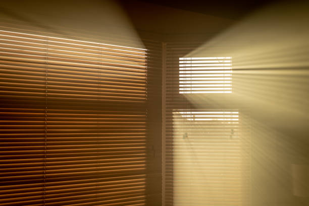 istock Sun coming through blinds into a smoky room 1058023234