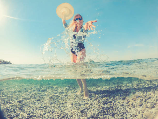Playful Young Woman in the Split Sea, half under water half above