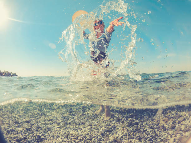 istock Playful Young Woman in the Split Sea, half under water half above 1058025092