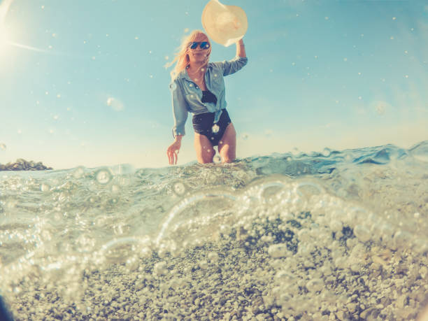 istock Playful Young Woman in the Split Sea, half under water half above 1058025160