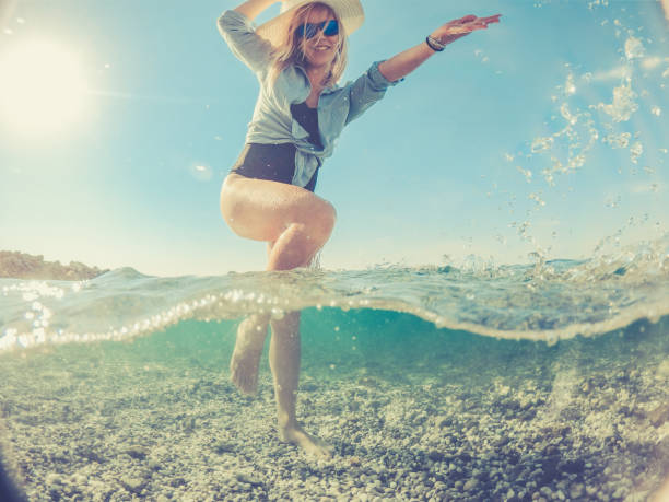 istock Playful Young Woman in the Split Sea, half under water half above 1058025228