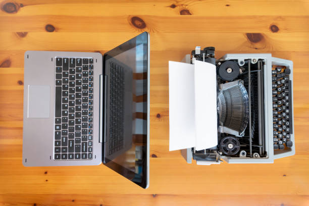 istock Old typewriter vs new laptop on the table. Concept of technology progress. 1058025426