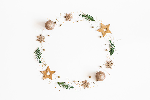 Christmas composition. Christmas wreath made of golden decorations, fir tree branches on white background. Flat lay, top view, copy space