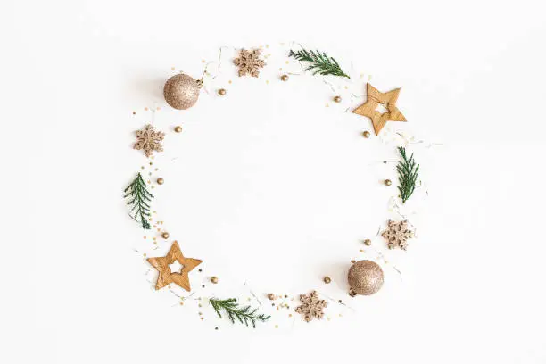 Photo of Christmas composition. Christmas wreath made of golden decorations, fir tree branches on white background. Flat lay, top view, copy space